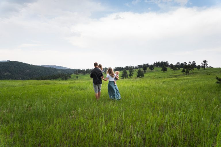 Mother daughter and dad walking in a field