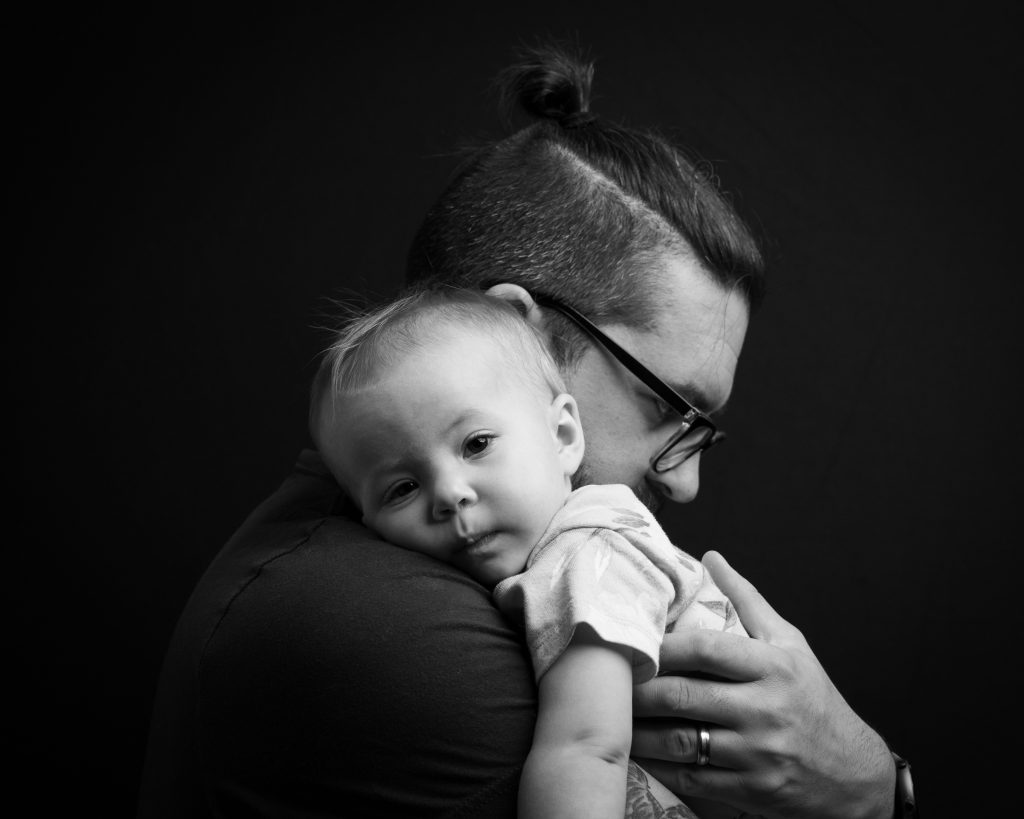 Picture of Thomas Stewart of Stewart Photography holding his daughter over his shoulder