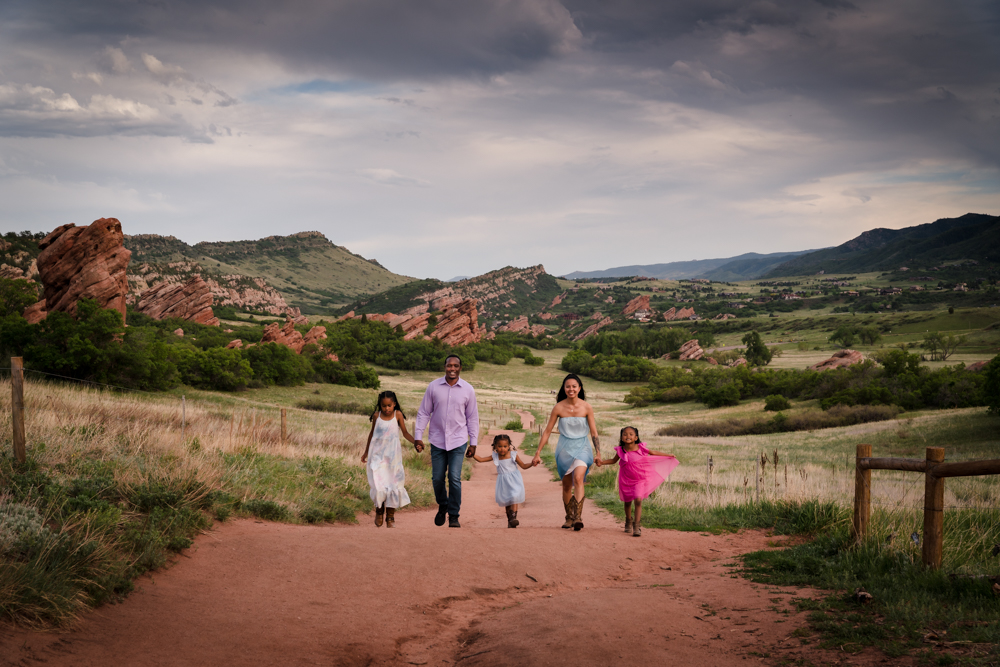 Denver Family photography - Family Walking down a red dirt path with beautiful red rock viewes
